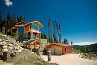Example of a large mountain style red three-story wood exterior home design in Calgary