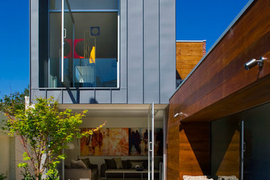 This is an example of a contemporary two-storey exterior in Melbourne with mixed siding and a flat roof.