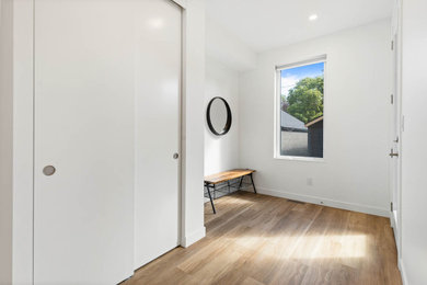 Modelo de puerta principal minimalista de tamaño medio con paredes blancas, suelo vinílico, puerta simple y suelo marrón