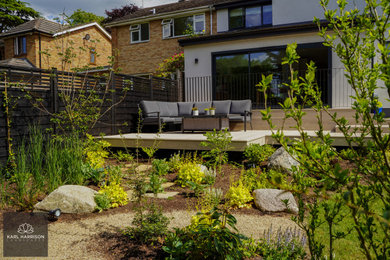 Inspiration for a medium sized contemporary back formal full sun garden for summer in Buckinghamshire with a garden path, decking and a wood fence.