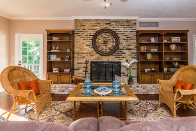 Mid-sized traditional formal open concept living room in Orlando with beige walls, dark hardwood floors, a standard fireplace, a brick fireplace surround and no tv.