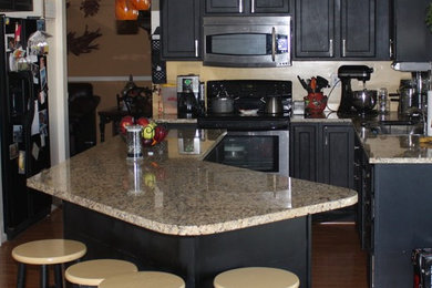 Inspiration for a light wood floor kitchen remodel in Baltimore with recessed-panel cabinets, black cabinets, granite countertops, beige backsplash and an island