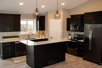 Eat-in kitchen - mid-sized modern u-shaped vinyl floor and beige floor eat-in kitchen idea in Other with an undermount sink, recessed-panel cabinets, black cabinets, quartz countertops, stainless steel appliances, an island and white countertops