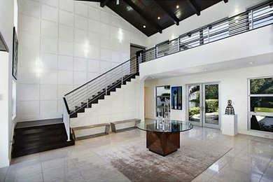 Photo of a large modern foyer in Miami with white walls, marble floors, a double front door, a glass front door and grey floor.