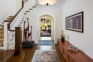 Inspiration for an expansive transitional foyer in San Francisco with white walls, medium hardwood floors, a single front door, a black front door and brown floor.