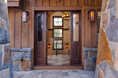 Large mountain style entryway photo in Seattle with brown walls and a dark wood front door