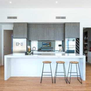 Mid-sized contemporary kitchen pantry ideas - Mid-sized trendy single-wall medium tone wood floor kitchen pantry photo in Canberra - Queanbeyan with a drop-in sink, dark wood cabinets, marble countertops, mirror backsplash, stainless steel appliances and an island