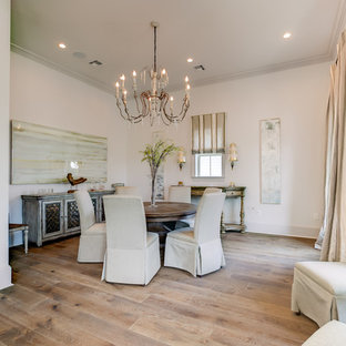 This is an example of a large traditional open plan dining in New Orleans with white walls, no fireplace, light hardwood floors and beige floor.