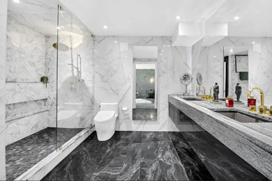 Large bathroom in London with grey cabinets, double sinks and a floating vanity unit.