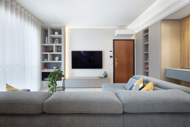 Foto di un soggiorno contemporaneo di medie dimensioni e chiuso con pareti grigie, pavimento in gres porcellanato, TV a parete e pavimento beige