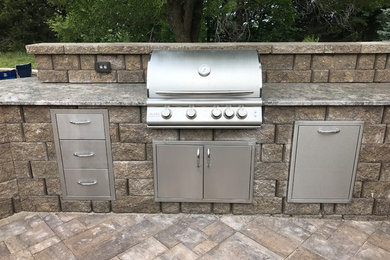 Patio kitchen - concrete paver patio kitchen idea in Other