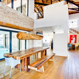 ハノーファーの巨大なラスティックスタイルのLDKの画像 (白い壁、無垢フローリング、暖炉なし、茶色い床)