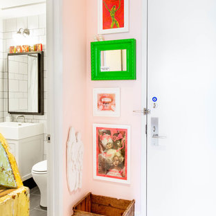 Idéer för mellanstora eklektiska ingångspartier, med rosa väggar, ljust trägolv, en enkeldörr, en vit dörr och brunt golv