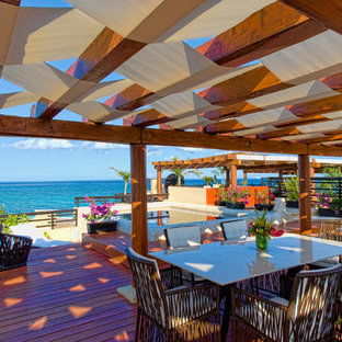 他の地域の中サイズのトロピカルスタイルのおしゃれな裏庭のデッキ (噴水、パーゴラ) の写真