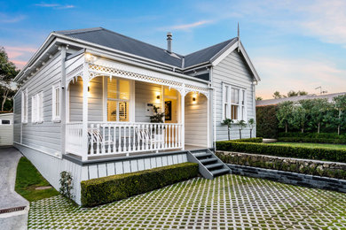 Esempio della villa grande grigia classica a un piano con rivestimento in legno, tetto a capanna, copertura in metallo o lamiera, tetto grigio e pannelli e listelle di legno