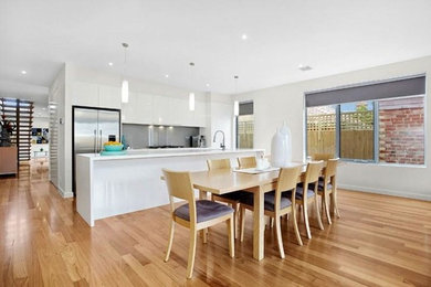 Design ideas for a modern open plan dining in Melbourne with white walls, light hardwood floors and no fireplace.