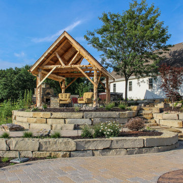 Foundational Rock Wall and Softscape Features Beneath Towering Pergola