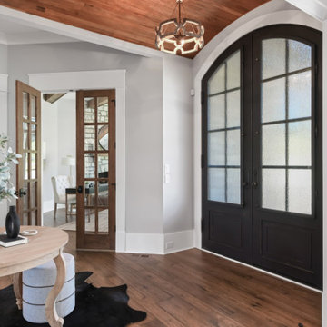 Luxury Modern Farmhouse Entry with Arched Black Steel Doors & Wood Ceiling