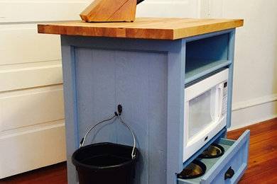Kitchen - small kitchen idea in Chicago with recessed-panel cabinets, blue cabinets and wood countertops
