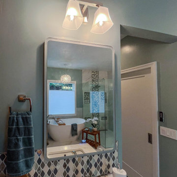 Primary Bath with Marble Look Tiled Shower and Free Standing Tub