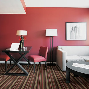 Small modern study in DC Metro with red walls, carpet, a freestanding desk and multi-coloured floors.