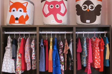 Example of a mid-sized minimalist girl medium tone wood floor kids' room design in Chicago with pink walls