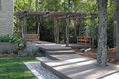This is an example of a mid-sized contemporary backyard partial sun formal garden in Toronto with decking.
