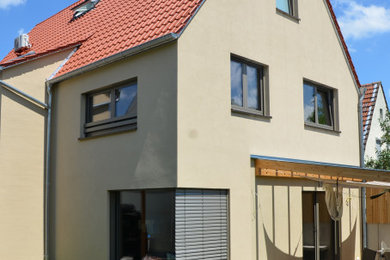Mittelgroßes, Dreistöckiges Modernes Einfamilienhaus mit Putzfassade, brauner Fassadenfarbe, Satteldach, Ziegeldach und rotem Dach in Sonstige
