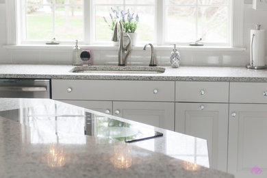 Eat-in kitchen - mid-sized contemporary u-shaped eat-in kitchen idea in Boston with an undermount sink, raised-panel cabinets, white cabinets, granite countertops, stainless steel appliances and an island