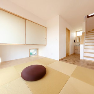 Mediterranes Wohnzimmer ohne Kamin mit weißer Wandfarbe, Tatami-Boden, grünem Boden und freistehendem TV in Sonstige