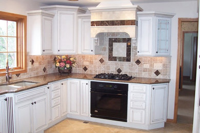 Example of a mid-sized classic u-shaped ceramic tile and beige floor open concept kitchen design in Chicago with a double-bowl sink, raised-panel cabinets, white cabinets, quartzite countertops, beige backsplash, ceramic backsplash, black appliances and a peninsula