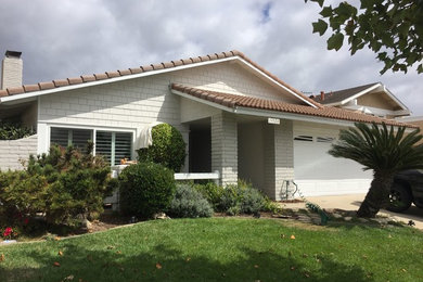 Example of a mid-sized arts and crafts white one-story stucco gable roof design in Los Angeles