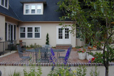 Inspiration for a mid-sized timeless backyard brick patio kitchen remodel in Denver with no cover