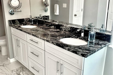 Example of a large minimalist master marble floor and white floor doorless shower design in Baltimore with recessed-panel cabinets, white cabinets, marble countertops, black countertops, an undermount tub, gray walls, an undermount sink and a hinged shower door