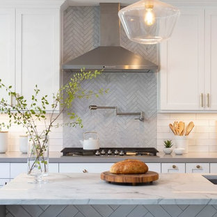 Esempio di una grande cucina classica con lavello sottopiano, ante in stile shaker, ante bianche, top in quarzo composito, paraspruzzi bianco, paraspruzzi con piastrelle diamantate, elettrodomestici in acciaio inossidabile, parquet scuro, isola, pavimento marrone e top bianco