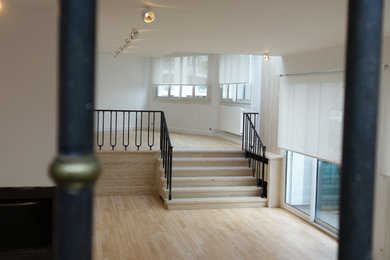 Idées déco pour un grand salon contemporain ouvert avec une salle de réception, un mur blanc, parquet clair, une cheminée standard, un manteau de cheminée en béton, un téléviseur dissimulé et un sol beige.