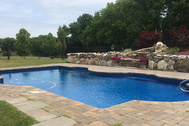 Pool - large traditional backyard brick and custom-shaped pool idea in Minneapolis
