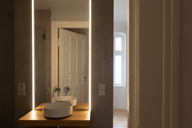 Kleines Modernes Badezimmer En Suite mit bodengleicher Dusche, Wandtoilette, grauen Fliesen, Keramikfliesen, Aufsatzwaschbecken, Falttür-Duschabtrennung und schwebendem Waschtisch in Berlin