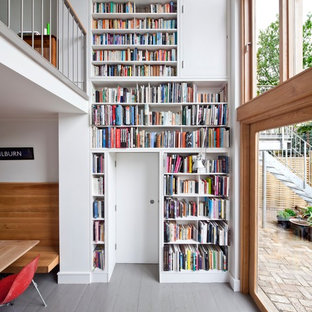 Bild på ett funkis vardagsrum, med ett bibliotek, vita väggar, målat trägolv och grått golv