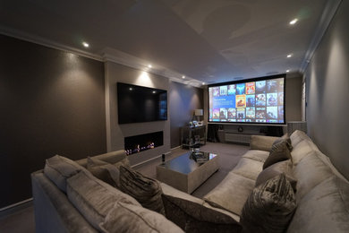 Photo of a medium sized modern enclosed home cinema in Other with grey walls, carpet, a projector screen and grey floors.