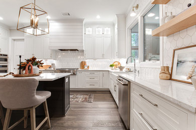 Open concept kitchen - large transitional u-shaped dark wood floor open concept kitchen idea in Atlanta with a farmhouse sink, beaded inset cabinets, white cabinets, quartz countertops, white backsplash, porcelain backsplash, stainless steel appliances and an island
