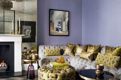 Photo of a mid-sized eclectic open concept living room in London with purple walls, dark hardwood floors, a standard fireplace, a stone fireplace surround and brown floor.