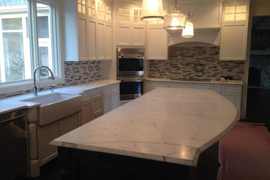 Example of a trendy eat-in kitchen design in New York with glass-front cabinets and an island