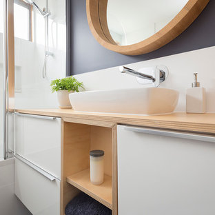 Immagine di una piccola stanza da bagno per bambini moderna con lavabo da incasso, ante bianche, top in legno, vasca da incasso, vasca/doccia, piastrelle bianche, piastrelle in ceramica e pavimento con piastrelle in ceramica