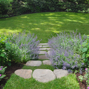 Mid-sized traditional sloped partial sun garden in Boston with natural stone pavers for summer.