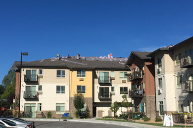 Example of a three-story apartment exterior design in Denver with a hip roof and a shingle roof
