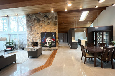 Imagen de salón abierto contemporáneo grande con suelo de baldosas de porcelana, chimenea de doble cara, televisor colgado en la pared, suelo gris y madera