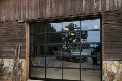 Custom Black Glass Garage Door on Rustic Home