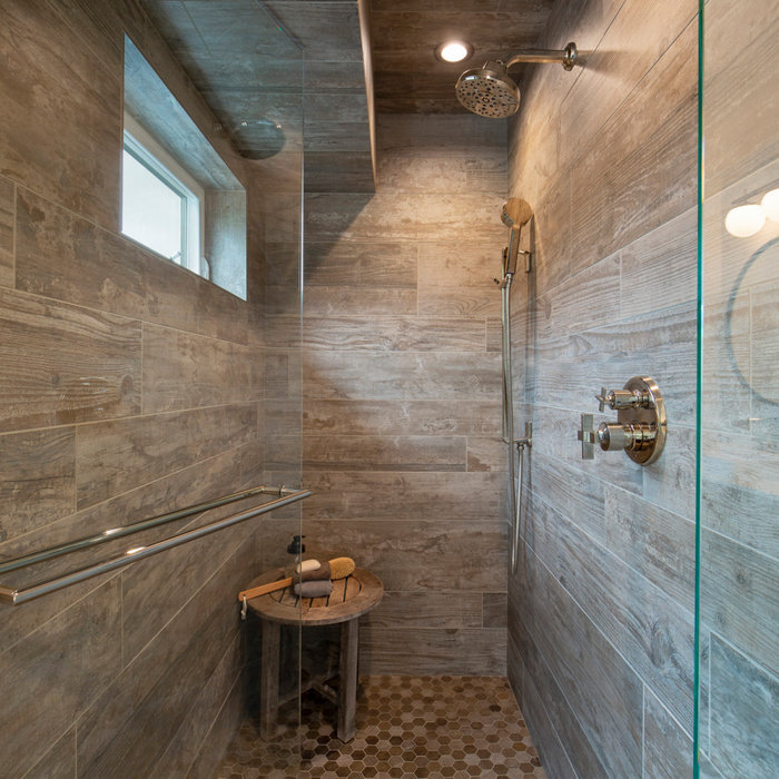 Alcove shower - cottage gray tile and wood-look tile alcove shower idea in San Francisco with a hinged shower door