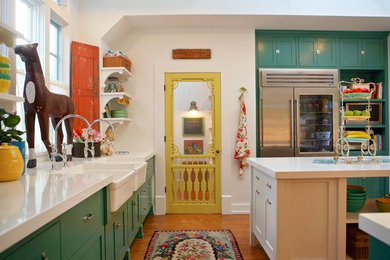 Kitchen - country light wood floor kitchen idea in Los Angeles with a farmhouse sink, shaker cabinets, green cabinets, quartz countertops, stainless steel appliances and an island